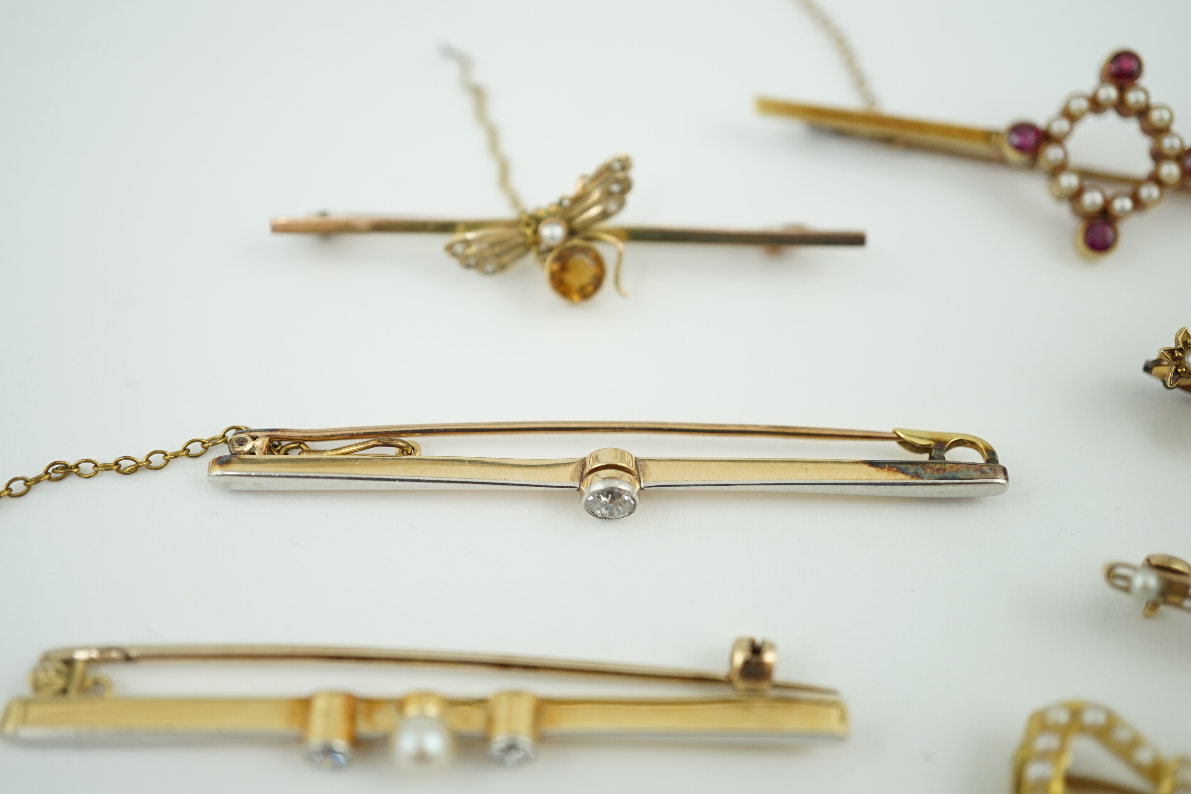 Five assorted Edwardian bar brooches, including a 15ct gold sapphire and diamond set three stone, a diamond and seed pearl, ruby? and seed pearl, a solitaire diamond set and a seed pearl and citrine bug brooch